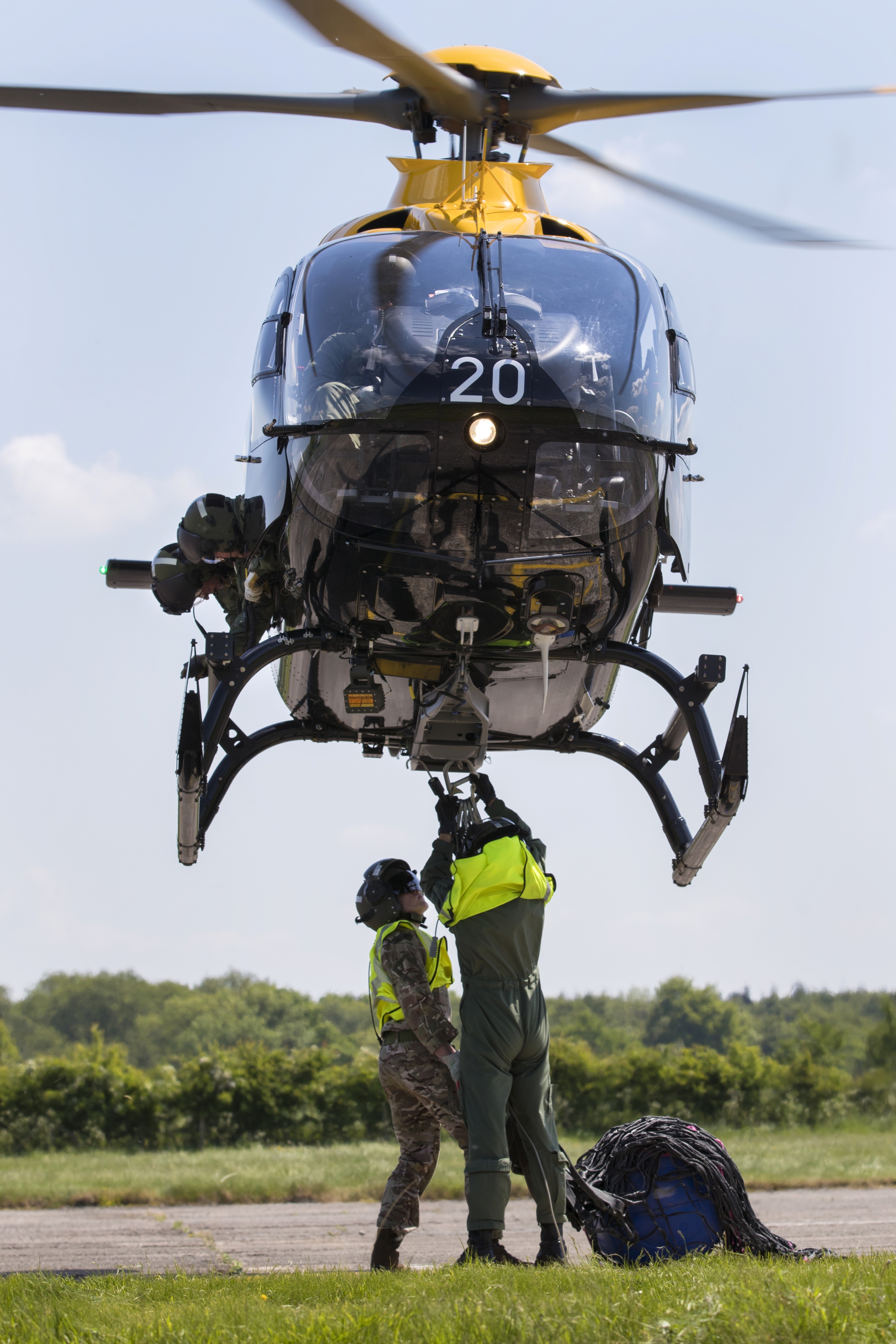Personnel attaching an Under Slung Load to a Juno helicopter.